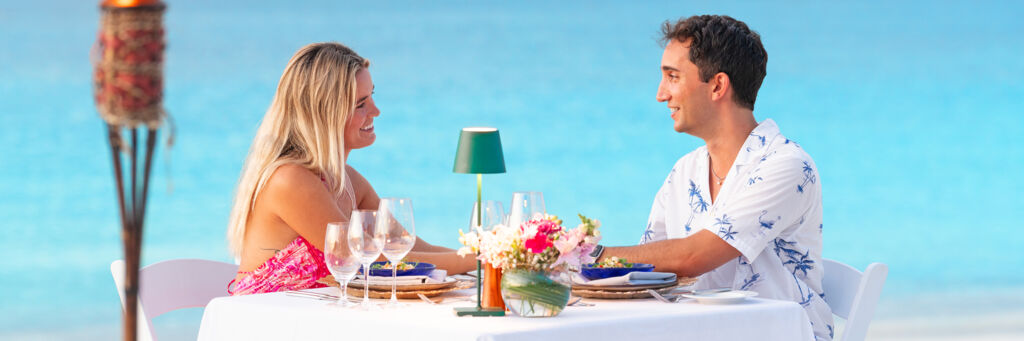 Couple enjoying a private beachfront dinner on Grace Bay, Turks and Caicos.