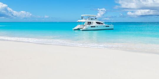 Yacht and couple at Water Cay beach in the Turks and Caicos