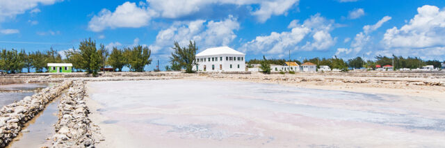 Salt ponds and walls with the white Harriot House in the distance on Salt Cay.