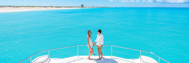 A couple on the bow of a yacht in the Turks and Caicos