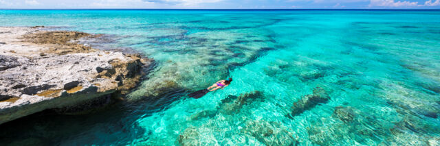 Snorkeler in clear turquoise water in the Turks and Caicos