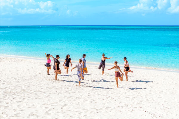 Group stretching on Grace Bay Beach.