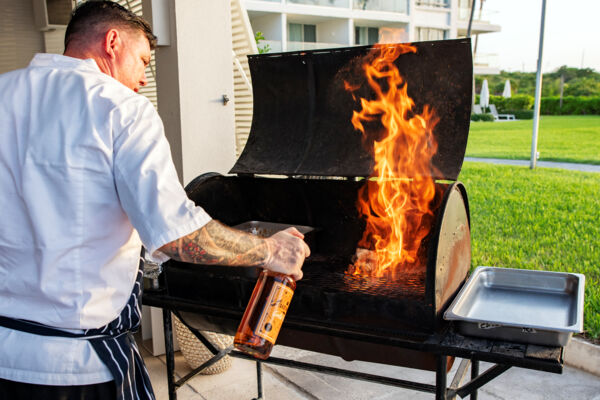 Chef grilling lobster tails at a beach BBQ in Turks and Caicos.