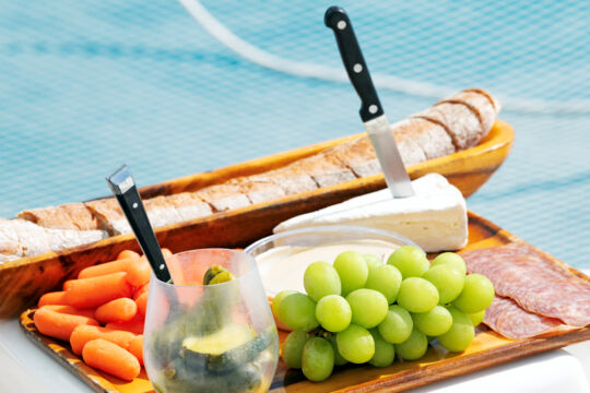 A charcuterie board with grapes, meat, and cheese on a catamaran in Turks and Caicos.