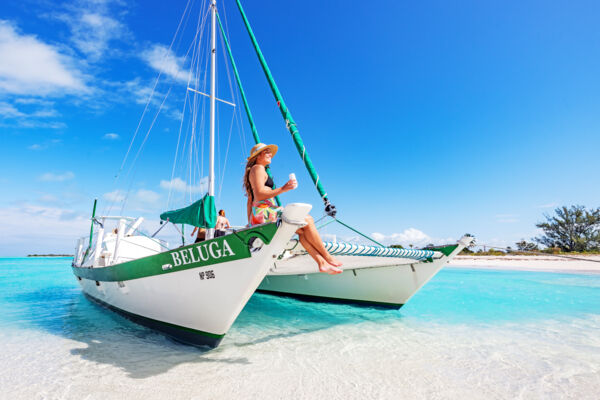 Woman sitting on the bow of a sailboat in Turks and Caicos. 