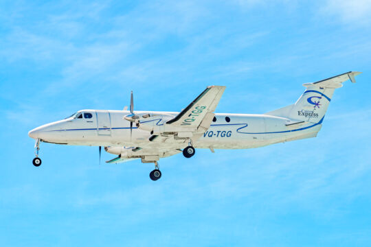 Small Caicos Express airplane flying in the sky