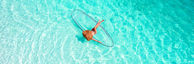 Floating on clear ocean water in the Turks and Caicos with a clear kayak