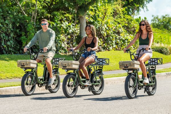 Three people riding electric bikes on the road in Turks and Caicos.