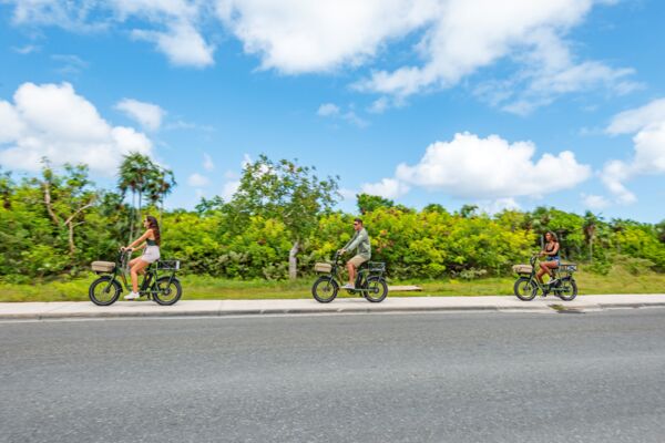 Three cyclists biking on the sidewalk in Turks and Caicos.