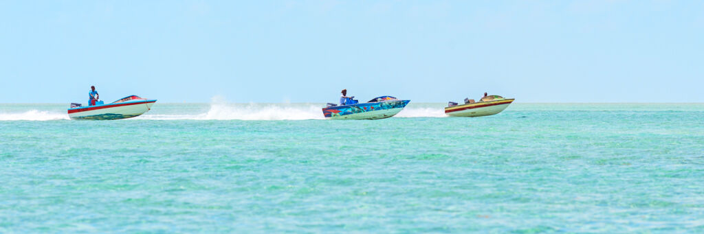 Boats race on a turquoise blue ocean for Fisherman's Day on South Caicos. 