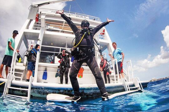 Diver jumping off a liveaboard yacht into the water in Turks and Caicos. 