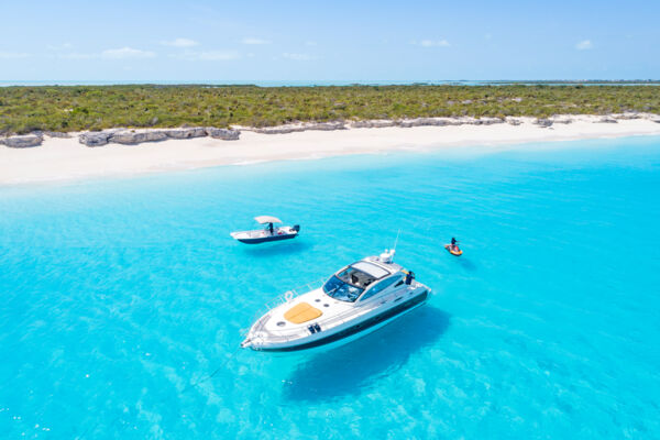 Aerial view of a yacht, skiff, and jet ski.