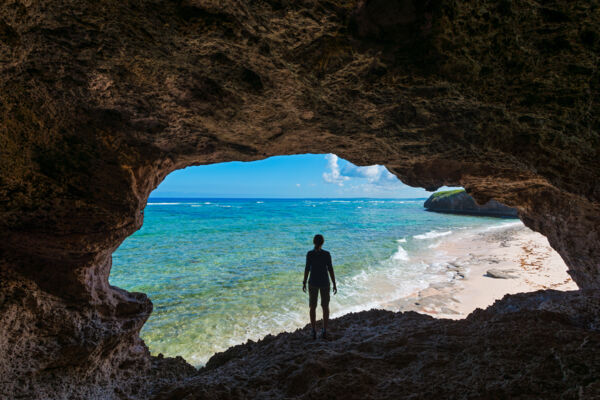 Person standing in a flank margin coastal cave on an uninhabited island in the Turks and Caicos