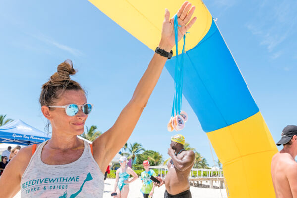 Woman holding a set of conch medals at Race for the Conch, Providenciales. 