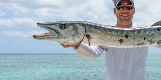 Fisherman holding up a barracuda in Turks and Caicos.