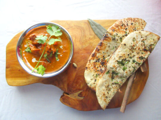Butter chicken and naan bread on a plate