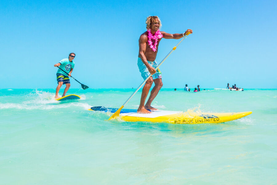 Two men paddleboarding in turquoise water