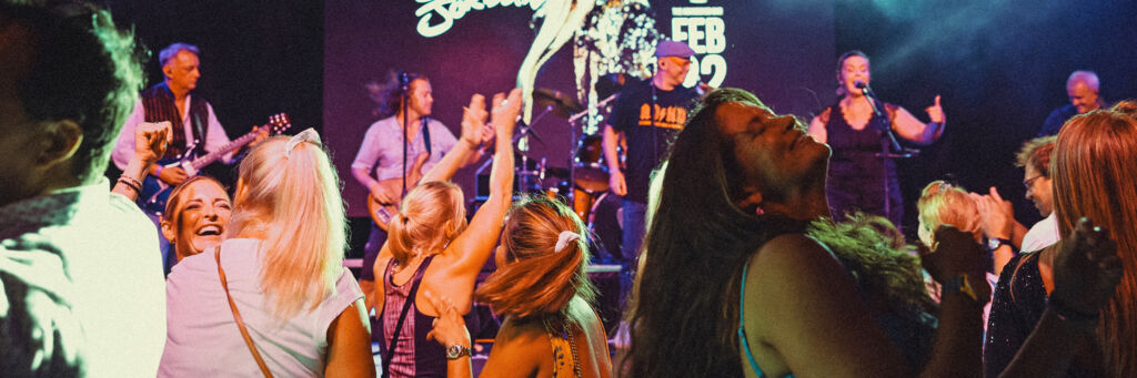 Rock band Weaponized Conch performing on stage at a concert venue in Turks and Caicos.