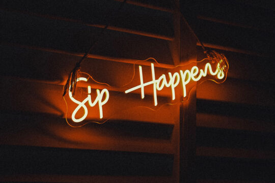 Neon sign that says 'Sip Happens' at a bar in Turks and Caicos.