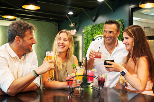 Four people enjoying beer and cocktails at a brewery taproom