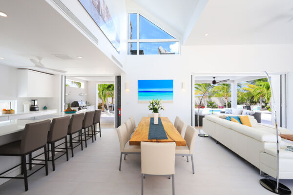 Full kitchen and interior dining area at a bright and luxurious villa in Turks and Caicos. 