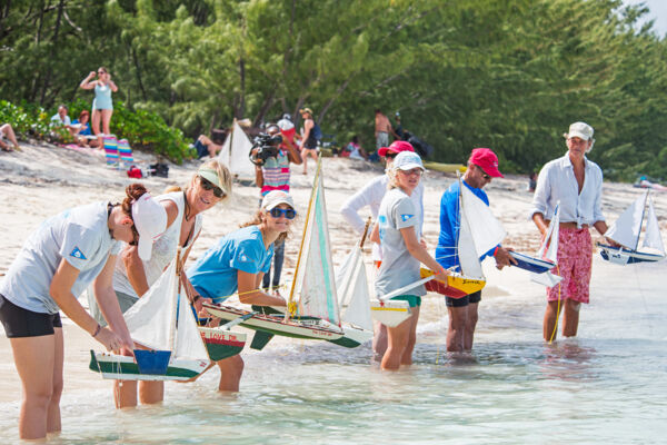 People launching model sailboats at Bambarra Beach, Middle Caicos. 