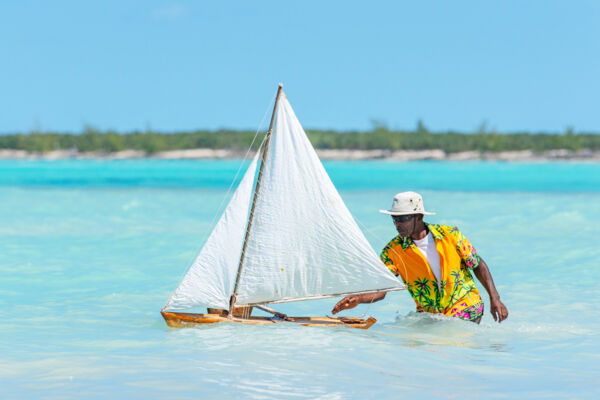 Man racing a model sailboat on Middle Caicos.