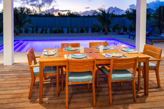 Dining table on a terrace next to a pool